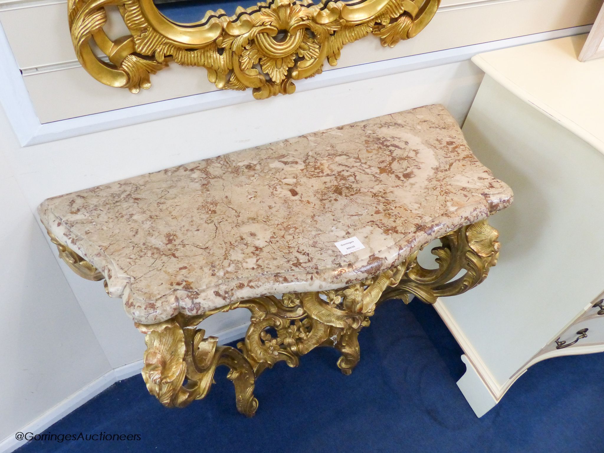 A 19th century rococo revival giltwood console table, 95cm wide, 86.5cm high and a similar later giltwood mirror, 113cm high, 64.5cm wide